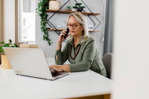 istock Senior woman using laptop and working at home 1448586025