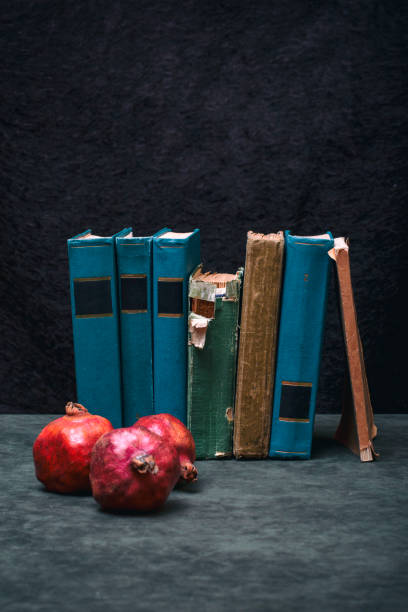 Ripe red pomegranates with books on the table