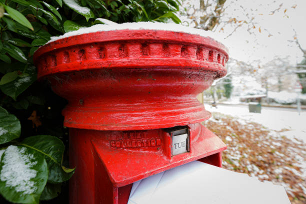 istock Senior man posting a letter in traditional red British mailbox 1448588220
