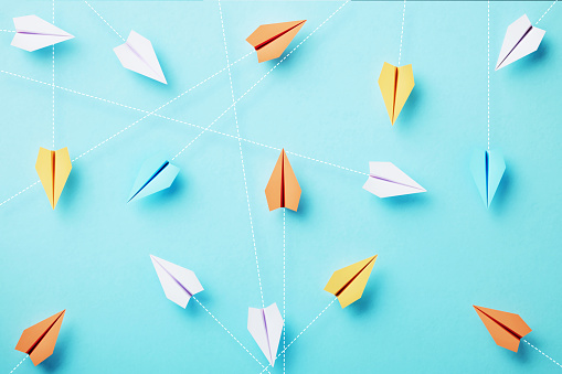 Paper planes are connected by dotted lines on blue background, Social media and networking concept.
