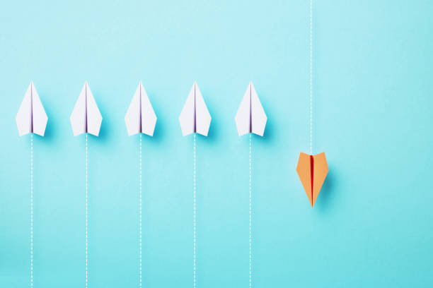 Paper planes flying on different directions on blue background,