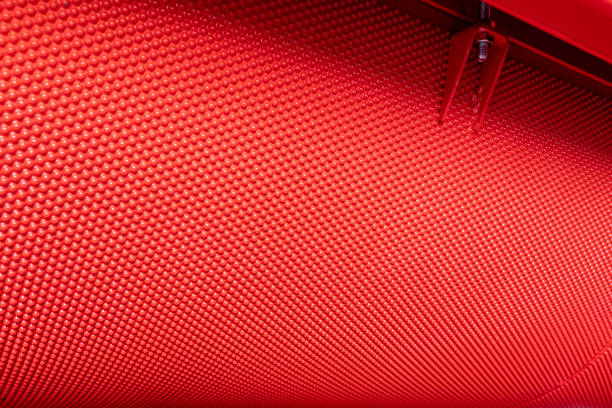 istock Fragment of a grain separation machine. Red metallic cell pockets sheet rolled into a cylinder 1448592725