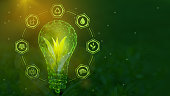 istock A tree sprout in a symbolic light bulb surrounded by symbols of green energy. Renewable energy sources, sustainable resources. Low-poly frame design 1448594124