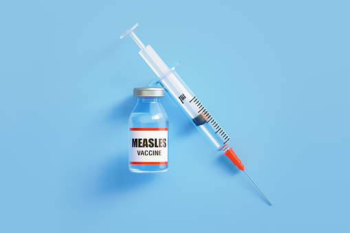 Measles vaccine and syringe on blue background, Horizontal composition with copy space.