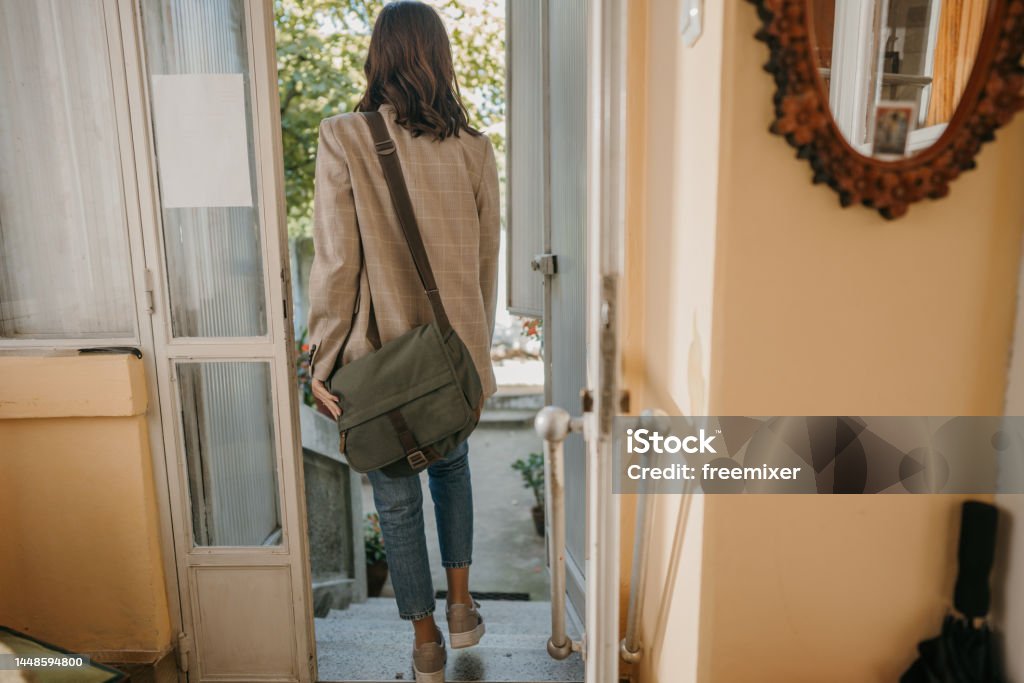 Woman leaving home Unrecognizable young woman is leaving her home. Leaving Stock Photo