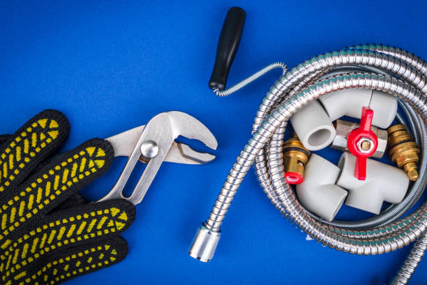 istock Plumbing tools and gloves for connecting water hoses on blue background 1448595749