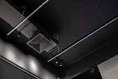 Supply and exhaust ventilation pipe on the ceiling of a retail space or warehouse or other commercial real estate object. Ceiling, lighting and communications in black