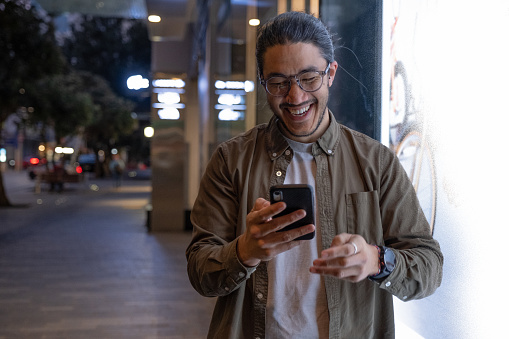 A male traveller using his smart phone to connect with friends and family while out and about in the City