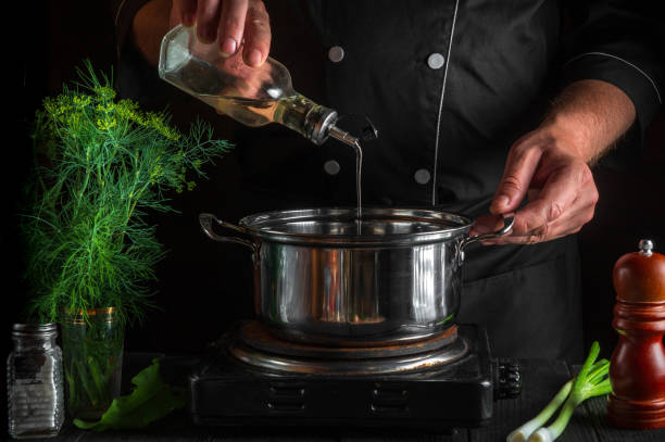 istock The chef adds oil to saucepan while making dumplings. Working environment on vintage kitchen table in restaurant. 1448599602