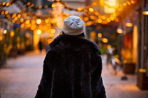 Christmas in Odense. Woman with fake fur and hat in Christmas decorated street.