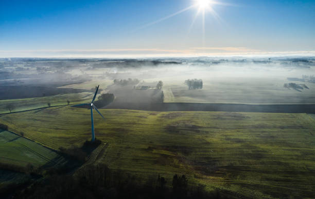 Aerial view of wind mills in hazy winter landscape seen from drone point of view