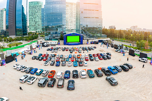 Vista panorámica de un auto cinema repleto de autos y rodeado de enormes edificios de oficinas y de departamentos en la ciudad de México
