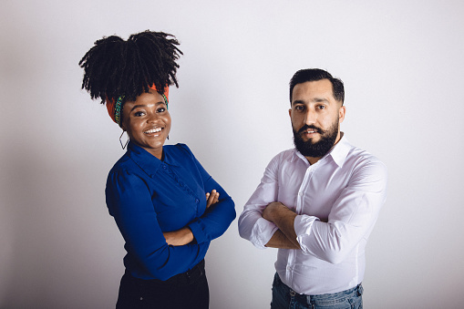 Multiracial group of two young adults in a studio portrait photo.