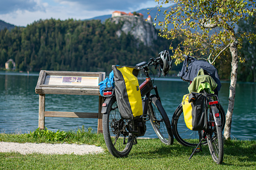 two bicycles with panniers parked on the shore of lake bled slovenia