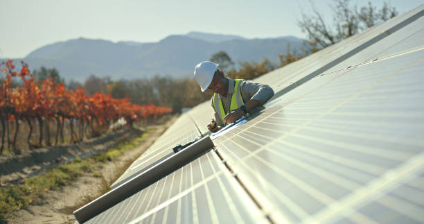 hombre negro, ingeniero o gestión de energía solar en sostenibilidad eléctrica, paneles solares o planta de red solar. trabajador, empleado o técnico en una granja de energía renovable, entorno biodegradable o ecológico - environmental conservation built structure solar power station building exterior fotografías e imágenes de stock