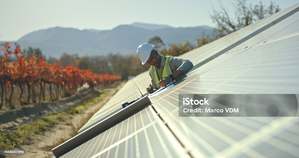 Black man, engineer or solar energy management in electricity sustainability, solar panels or sun grid plant. Worker, employee or technician on renewable energy farm, biodegradable environment or eco Solar Energy Stock Photo