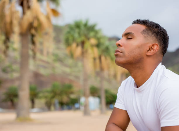 istock Man with black skin meditating on beach 1448610868