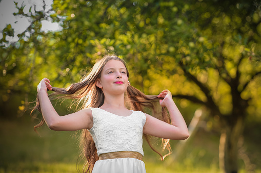 Portrait of a young Caucasian girl smiling outside.