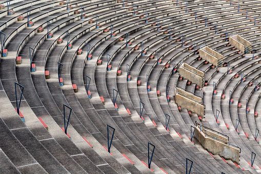 Looking down on the curved arc of rows of concrete bench seating and steps in an old sports stadium - Boston Massachusetts