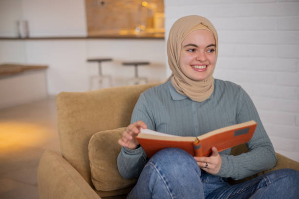 istock Happy woman reading book at home 1448616255