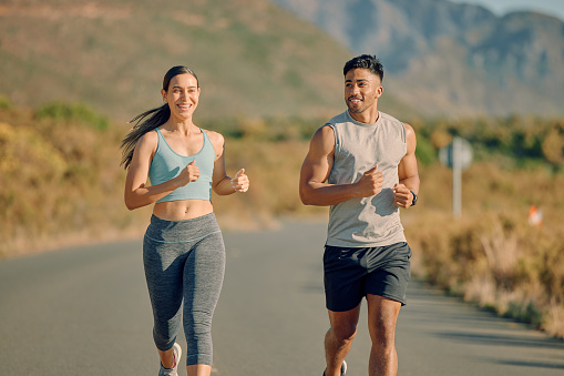 Runner couple, street and nature in summer, mountains or countryside in fitness workout, wellness or health. Man, woman and teamwork running on road for training, exercise or self care in sunshine