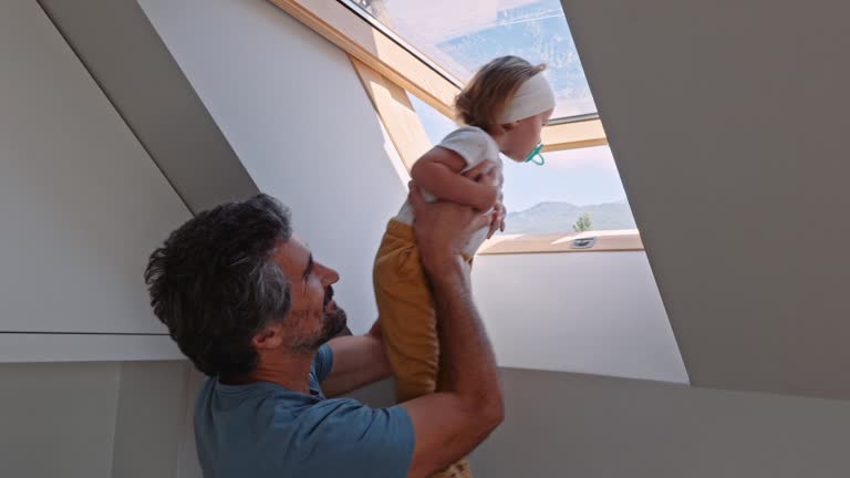 Dad and kid open roof window and look out.