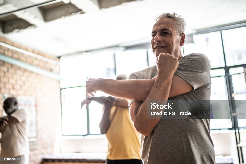 Senior man stretching in a exercise class Stretching Stock Photo