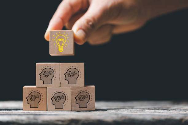 istock Concept creative idea and innovation. Hand choose wooden cube block with head human symbol and light bulb icon. knowledge and education concept. learning with smart technology. 1448620859