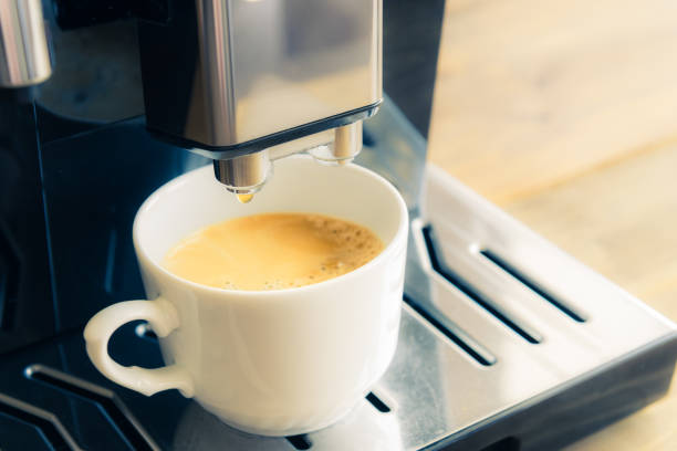 istock White ceramic cup of fresh espresso with foam in the coffee machine. 1448621969