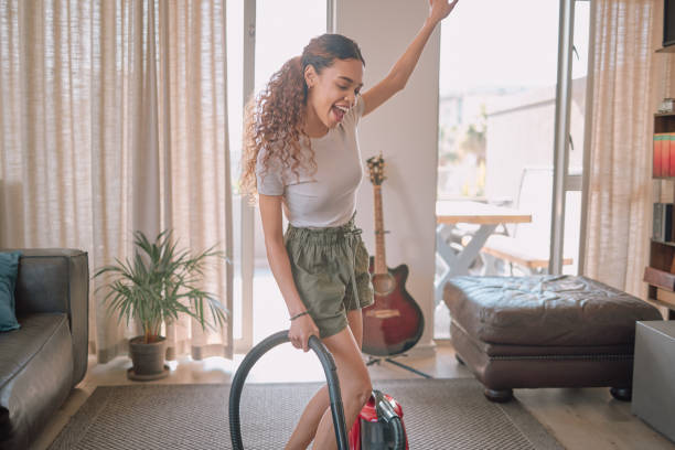 cleaning, vacuum and sing with a black woman doing housework in her home living room alone. happy, housekeeping and carefree with a female cleaner signing while in her house to clean for chores - spring cleaning women cleaning dancing imagens e fotografias de stock