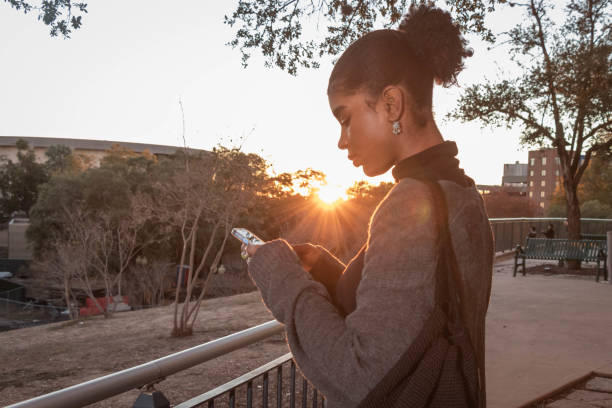istock Lens Flare / Woman Using Her Smart Phone 1448629657
