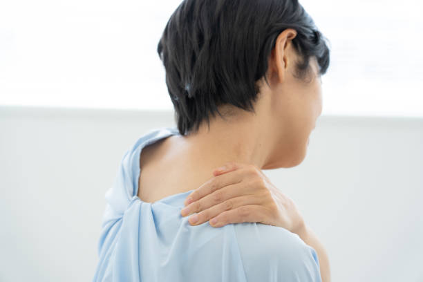 Woman suffering from stiff shoulders stock photo
