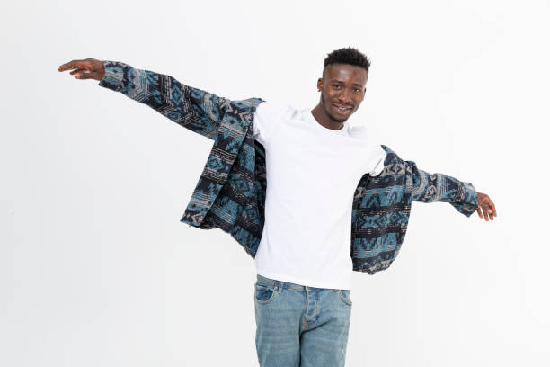 istock Young black man smiling while putting on his shirt. 1448632315