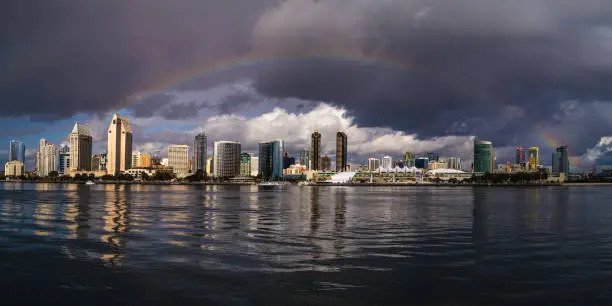 Photo of Rainbow over San Diego Downtown Skyline and skyscraper buildings, romantic cityscape, and dramatic cloudscape