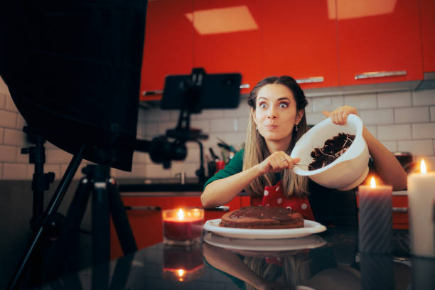 istock Happy Vlogger Demonstrating a Cake Recipe on Camera 1448643872