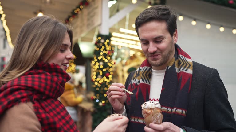 Couple eating street food on Christmas market