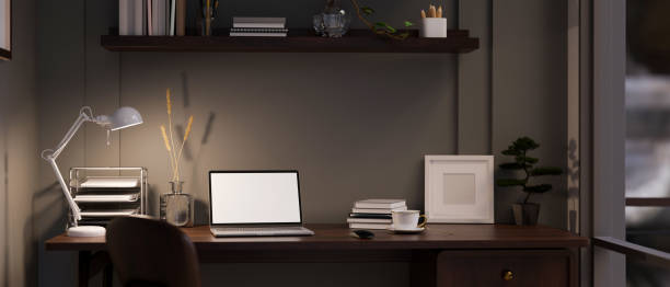 istock Modern dark office working space at night with laptop mockup on table against the black wall. 1448653540