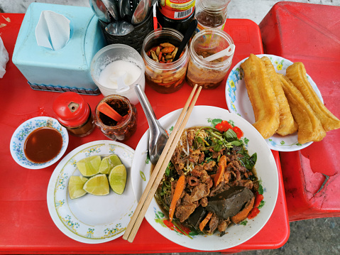 Cambodian yellow noodle soup with pork and pig blood at the restaurant on the street food in Phnom Penh, Cambodia.