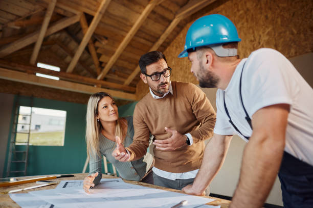 Young couple talking about housing design with manual worker.
