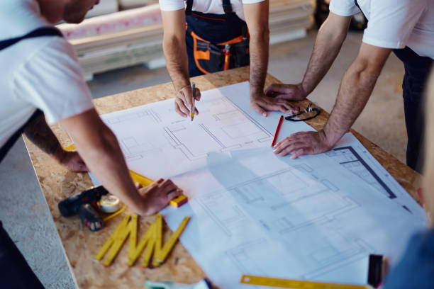 istock Team of unrecognizable workers working on plans at construction site. 1448678291