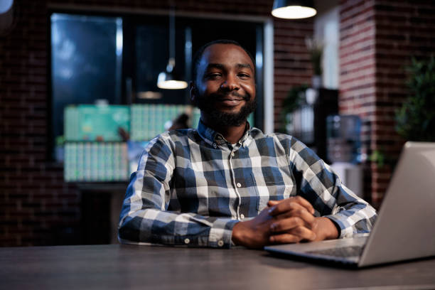 istock Forex stock market analyst in trading agency workspace sitting at table while smiling at camera. 1448678327