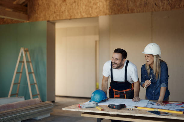 istock Cheerful female inspector and manual worker working at construction site. 1448678361