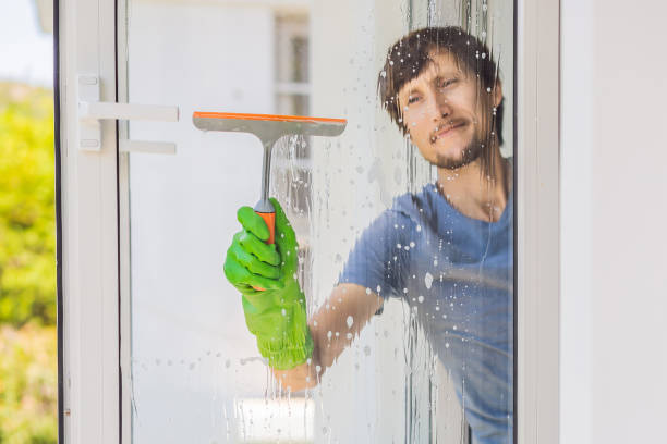 istock A young man cleaning the window with a window cleaner 1448678517