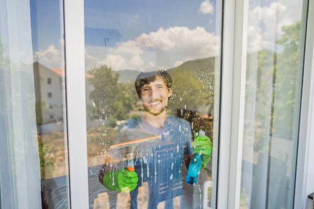istock A young man cleaning the window with a window cleaner 1448678522