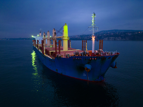 Aerial top view cargo bulk carrier ship on the sea at night