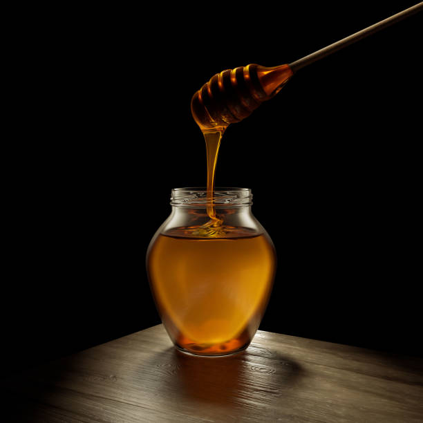 istock Honey on a black background with a honey spoon. 1448679304