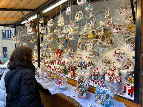 Woman looking at a Christmas market stall in a city centre in Colmar,Alsace