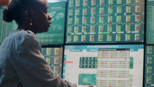 istock Female broker looking at multi monitors with forex exchange statistics 1448679771