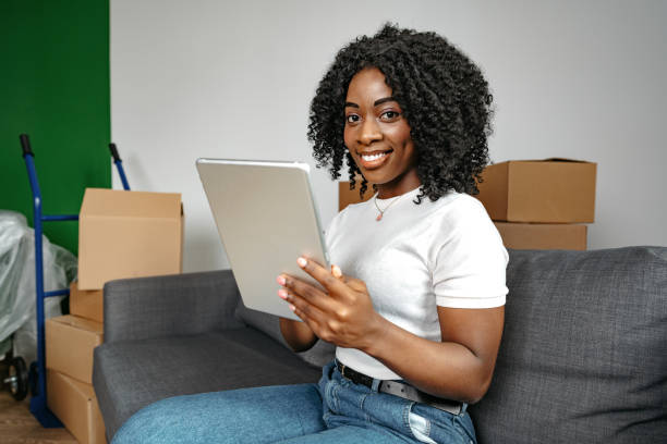 istock Young african woman using digital tablet and smiling while resting at home. 1448681446