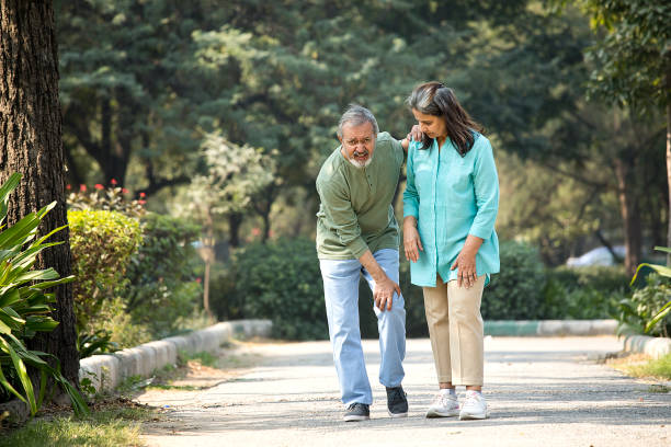 Senior man is having knee pain in the park Senior man is having knee pain in the park indian man walking in park stock pictures, royalty-free photos & images